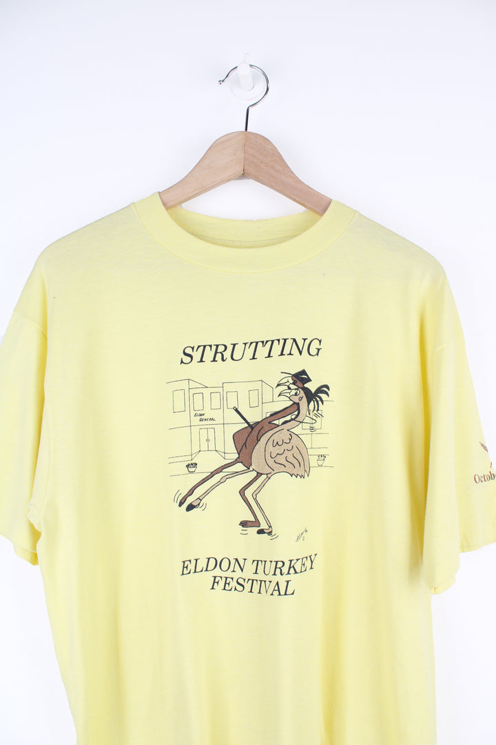 Vintage 1986 'Strutting' Eldon Turkey Festival in a pale yellow with printed graphic on the front, by Hanes