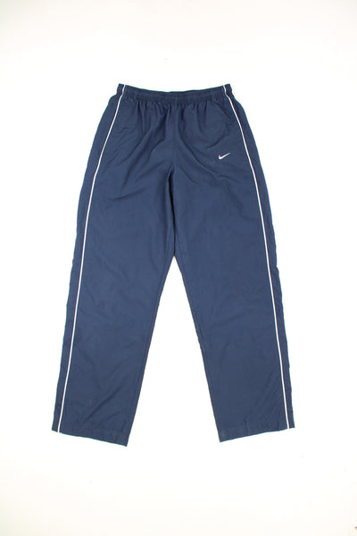 Nike Tracksuit Bottoms in a blue colourway with white stripes going down the sides, adjustable waist and has the swoosh logo embroidered on the front.