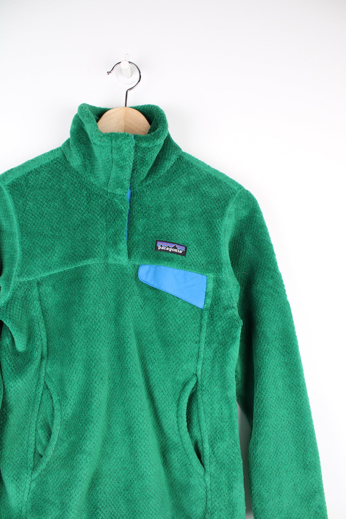 Patagonia Pullover Fleece in a green colourway, quarter button up, multiple pockets, and has the logo embroidered on the front.