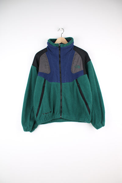 The North Face Fleece in a green, blue and black colourway, zip up with side pockets, and has the logo embroidered on the front and back.