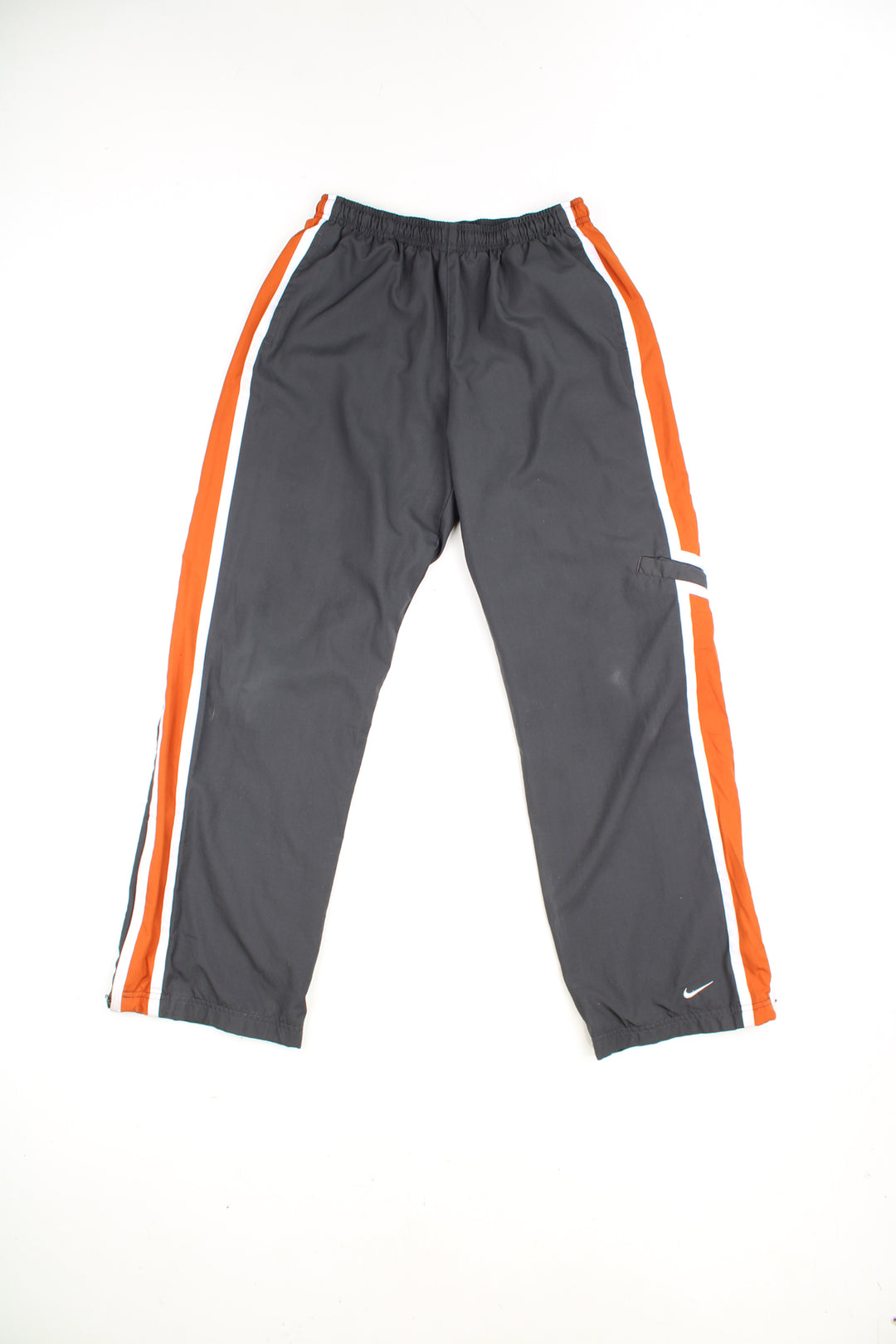 Nike Tracksuit Bottoms in a grey, white and orange colourway with stripes going down the sides, adjustable waist, cargo style pocket, and has the swoosh logo embroidered on the front.