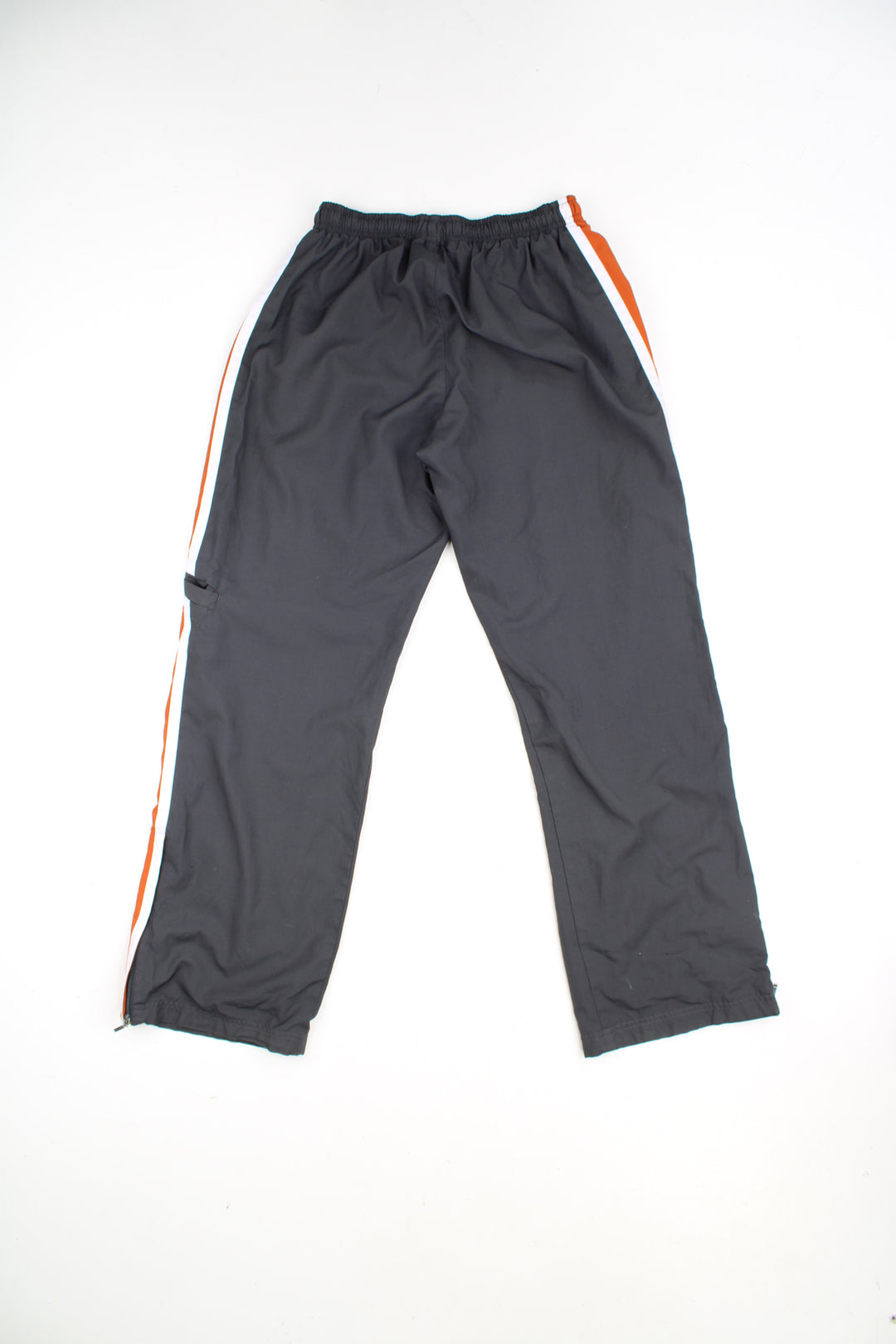 Nike Tracksuit Bottoms in a grey, white and orange colourway with stripes going down the sides, adjustable waist, cargo style pocket, and has the swoosh logo embroidered on the front.