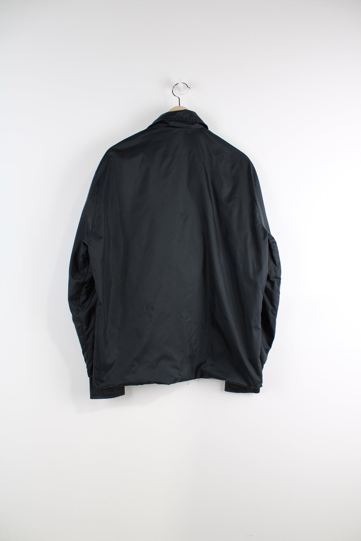 Vintage all black, button up nylon coach jacket by Suzuki. Features embroidered badge on the chest  