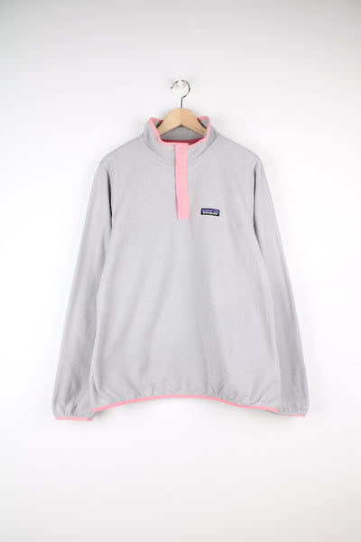 Patagonia Fleece in a grey and pink colourway, quarter button up, and has the logo embroidered on the front.