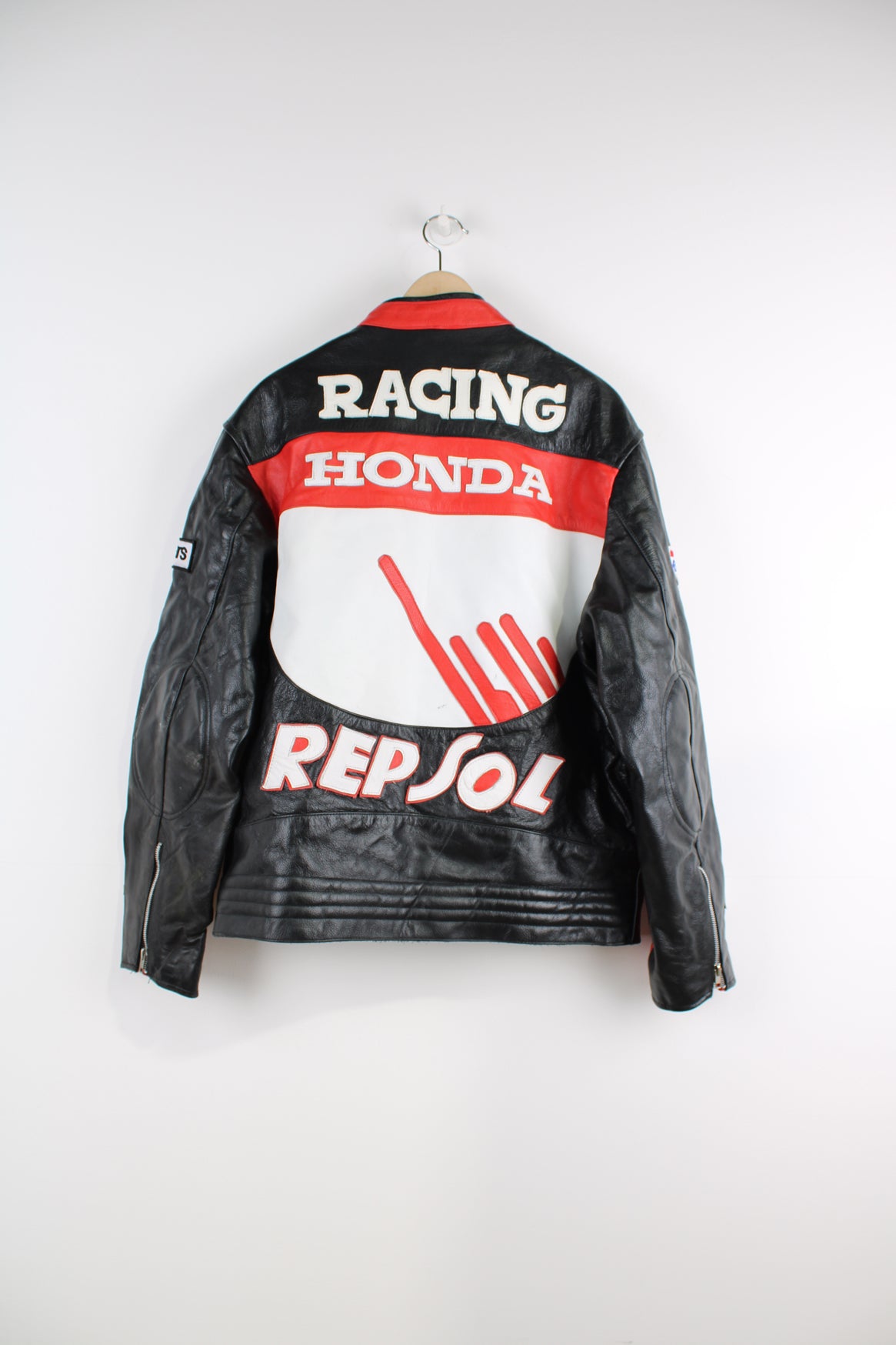 Vintage Honda Repsol zip through leather motorcycle racing jacket in red and black, features embroidered sponsor badges through out