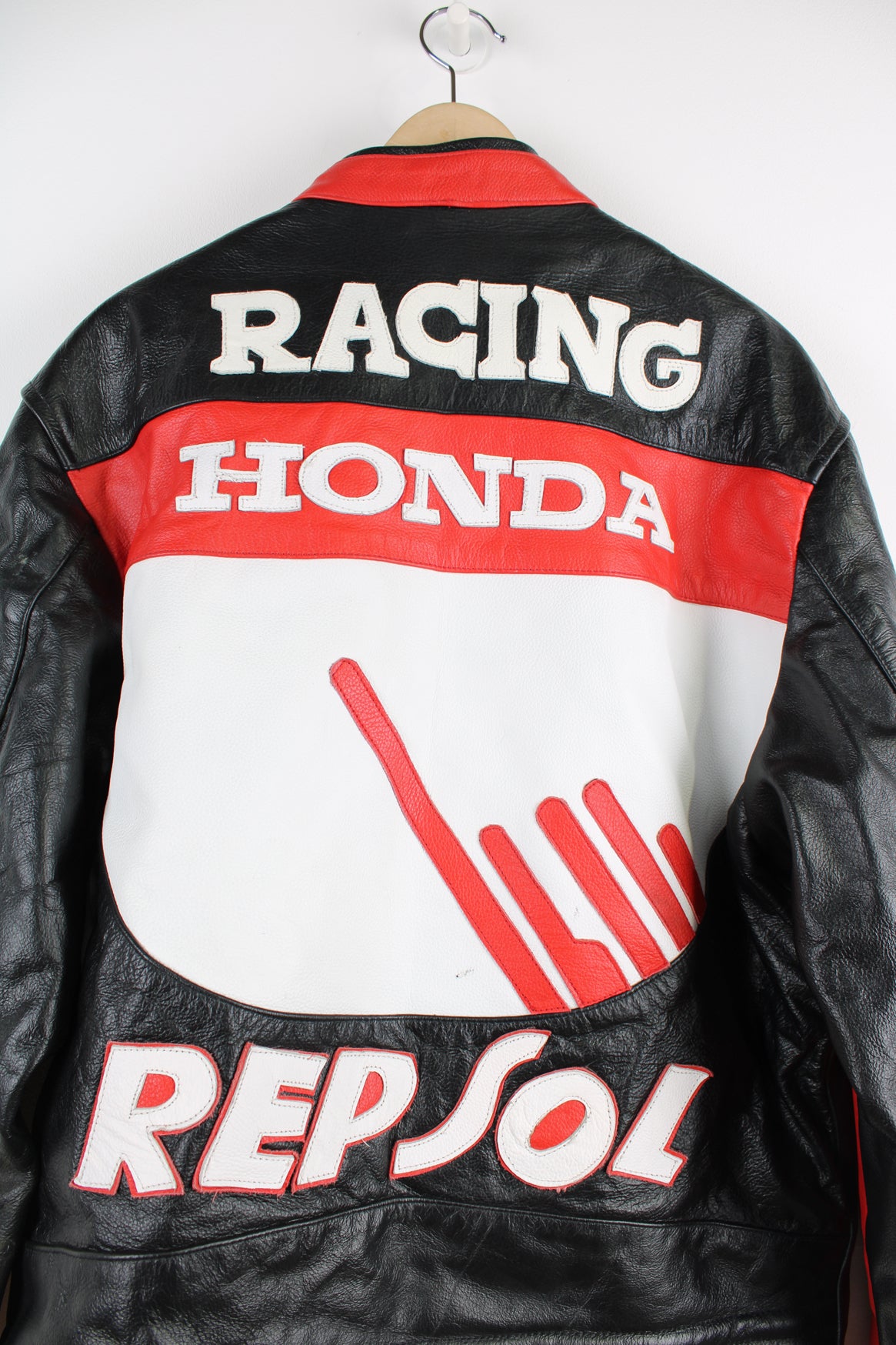 Vintage Honda Repsol zip through leather motorcycle racing jacket in red and black, features embroidered sponsor badges through out