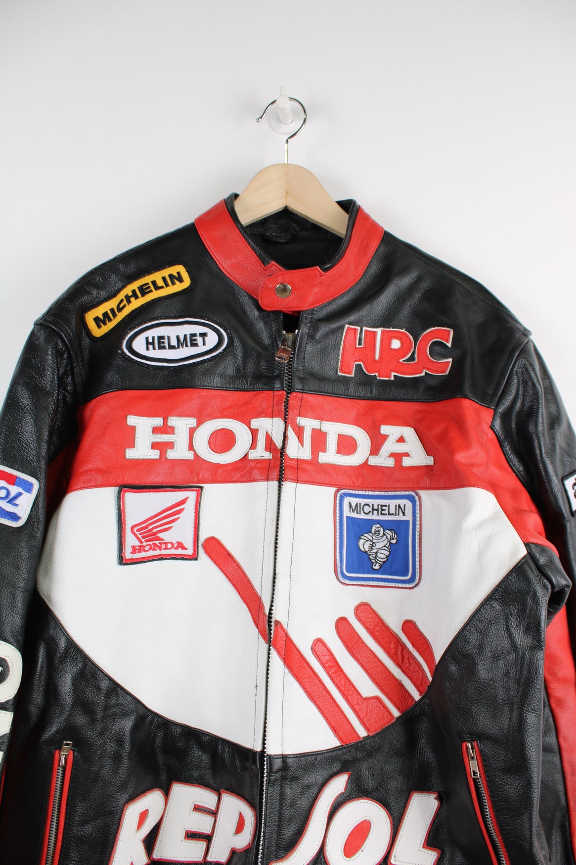 Vintage Honda Repsol zip through leather motorcycle racing jacket in red and black, features embroidered sponsor badges through out