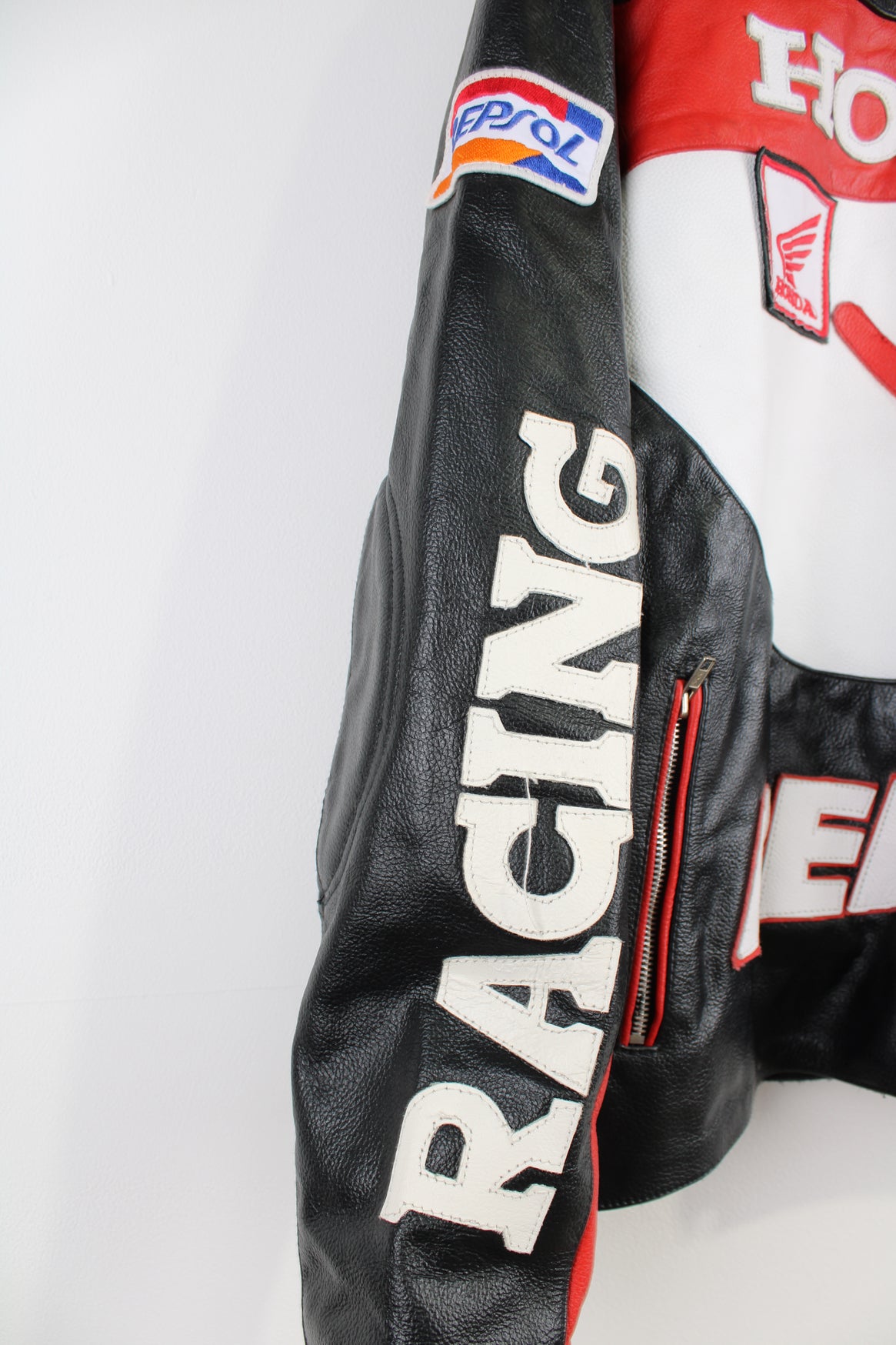 Vintage Honda Repsol zip through leather motorcycle racing jacket in red and black, features embroidered sponsor badges through out