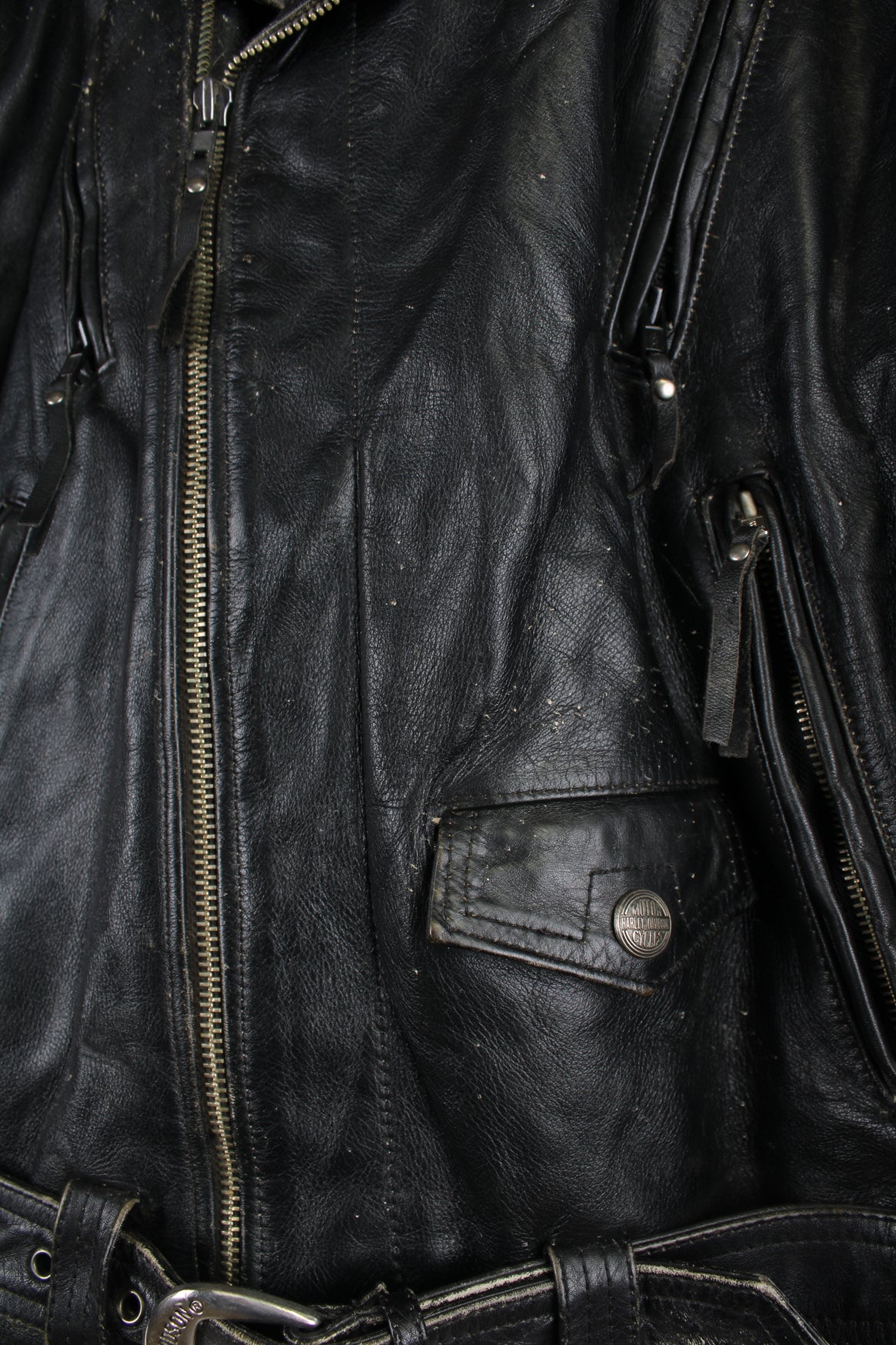 Vintage Harley Davidson Leather Biker Jacket in a black colourway, zip up with big collar, multiple pockets and ventilation zips, and has an adjustable waist belt.