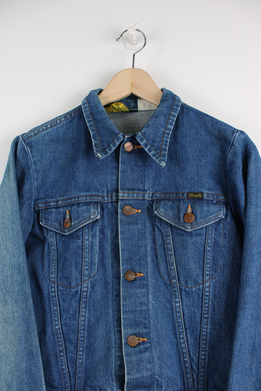 Vintage Wrangler Denim Jacket in a blue colourway, button up, double chest pockets, and has logo embroidered on the chest.