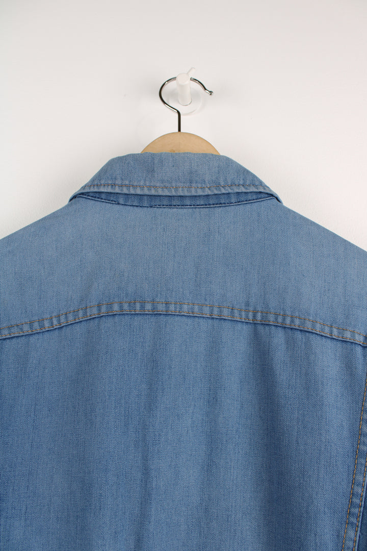 Vintage Lee Denim Jacket in a blue colourway, button up, double chest pockets, and has logo embroidered on the chest.