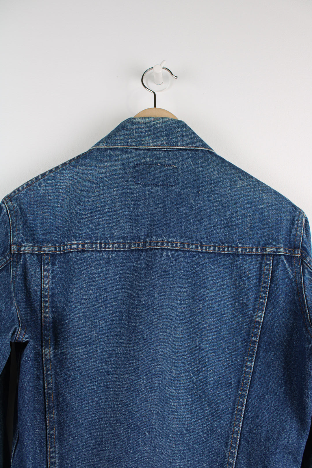 Vintage Levi's Denim Jacket in a blue colourway, button up, double chest pockets, and has orange tab logo embroidered on the chest.