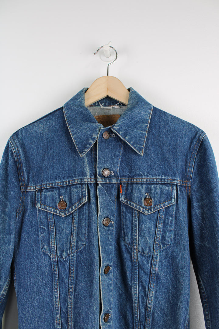 Vintage Levi's Denim Jacket in a blue colourway, button up, double chest pockets, and has orange tab logo embroidered on the chest.