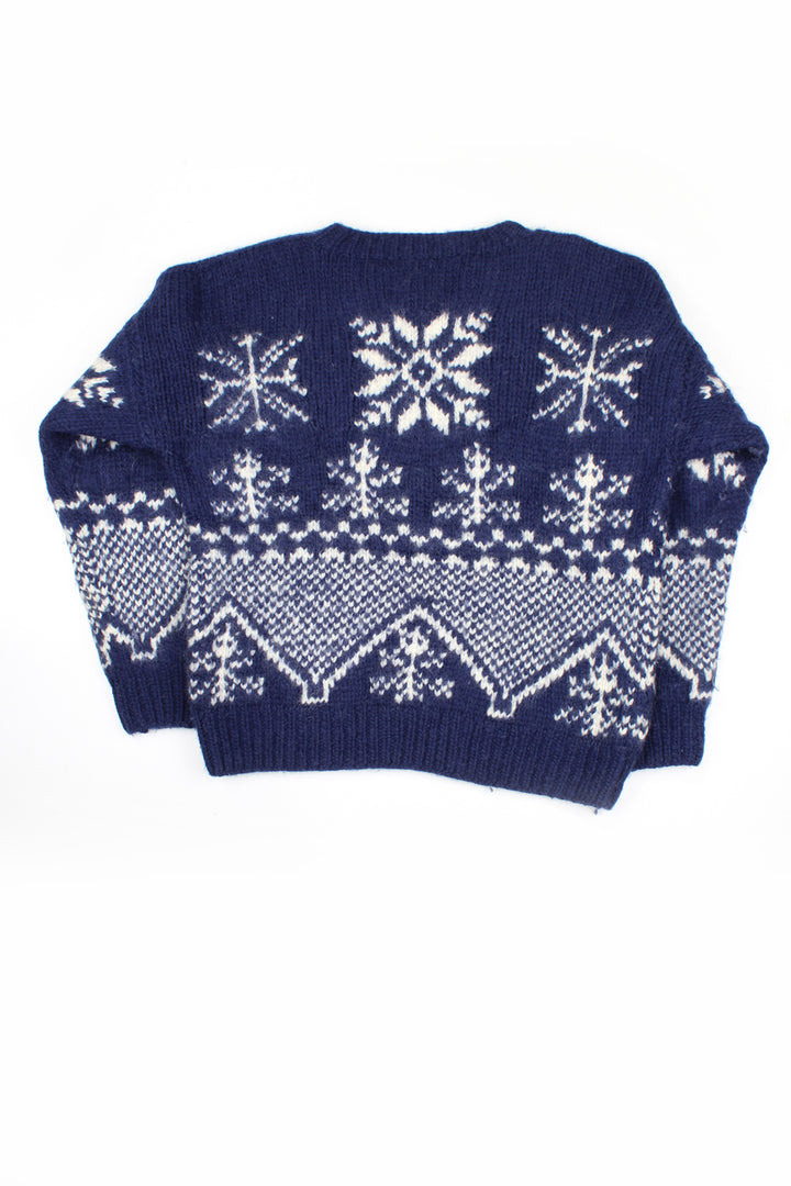 Vintage blue hand knit 100% wool jumper. Navy blue with white snowflake motif throughout.   good condition - some slight discoloration on the neck but nothing of note.  Size in Label:  S - Measures more like a M for a more fitted look.