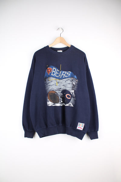 Vintage Chicago Bears NFL Sweatshirt in a blue colourway, Nutmeg tag, and has big embroidered logo spell out alongside printed football graphic.
