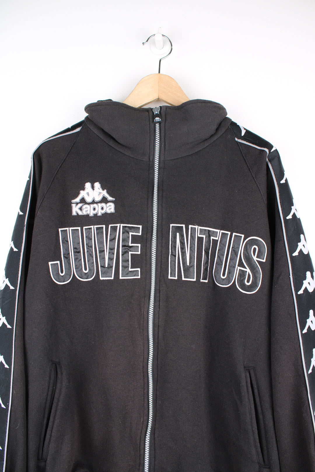 Kappa Juventus Track Jacket in the black and white colourway, zip up sweatshirt, side pockets, Kappa logo going down the sleeves, and has the spell out embroidered on the front and back.