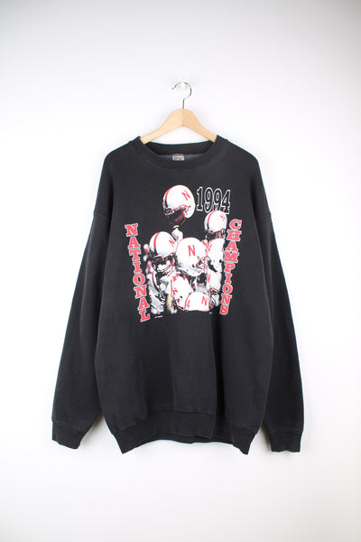 University of Nebraska Cornhuskers Football Team 1994 Champions Sweatshirt in a black colourway, and has the team champions graphic printed on the front.