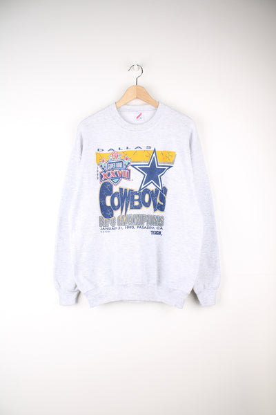 Vintage Dallas Cowboys 1993 NFC Super Bowl Champions Sweatshirt in a grey colourway, and has a big graphic including the logo and spell out printed on the front.