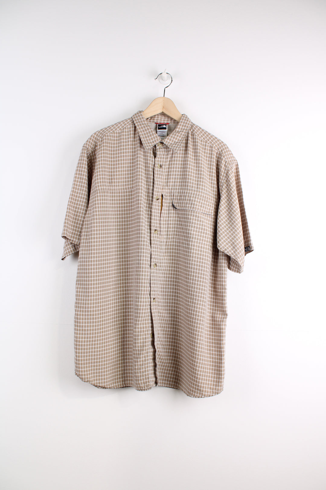 The North Face Short Sleeve Plaid Shirt in a tan and orange colourway, button up with chest pockets, and logo embroidered on the side.