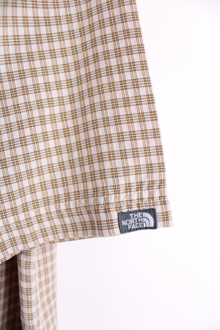 The North Face Short Sleeve Plaid Shirt in a tan and orange colourway, button up with chest pockets, and logo embroidered on the side.