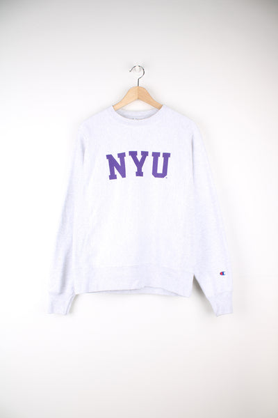 Champion Reverse Weave, New York University Sweatshirt in a grey and purple colourway, with the Uni initials printed across the front and the Champion logo embroidered on the left sleeve.