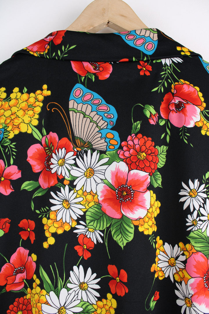 Vintage 70's Patterned Blouse in a black colourway with multicoloured flowers printed all over, button up, and has a camp collar.