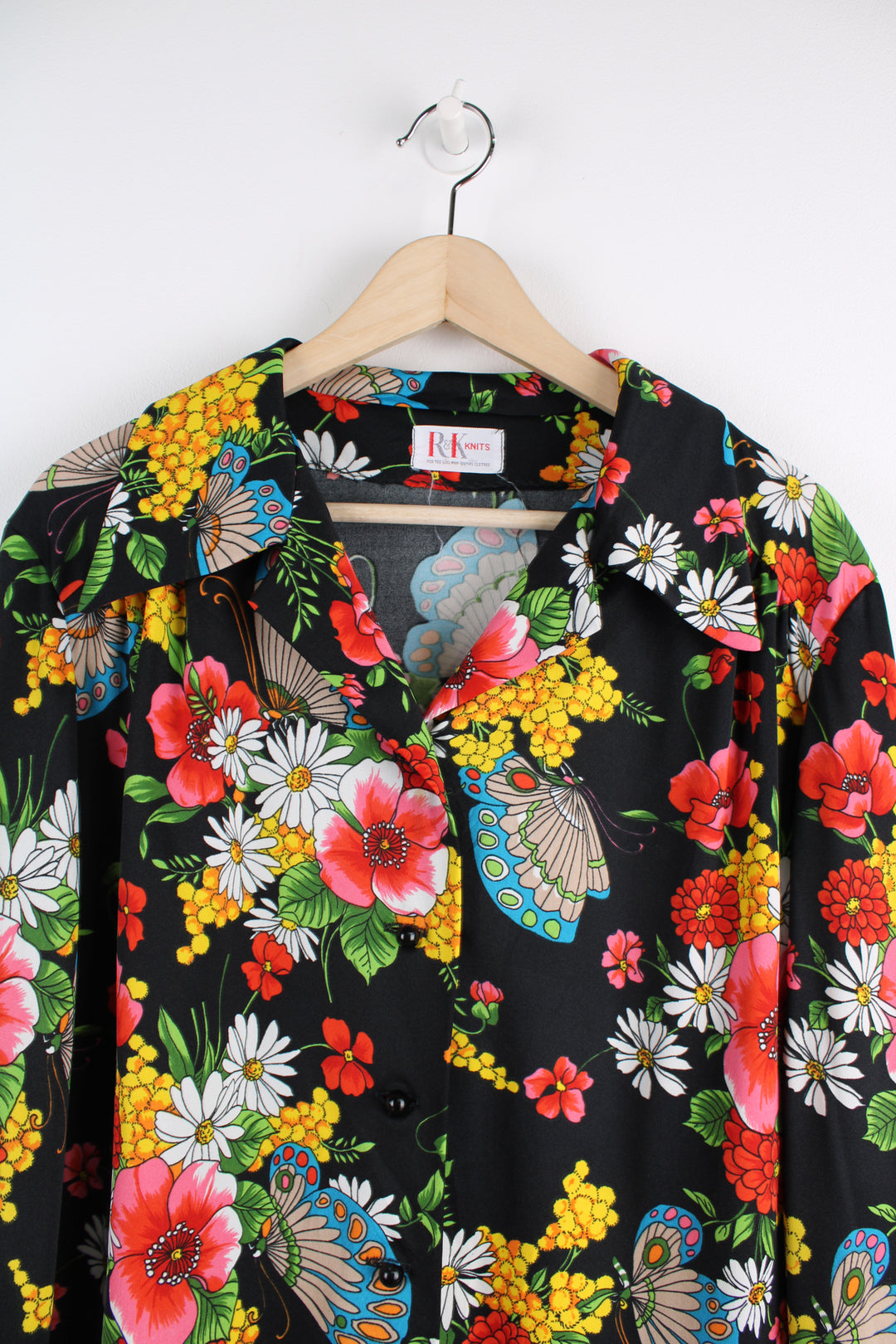 Vintage 70's Patterned Blouse in a black colourway with multicoloured flowers printed all over, button up, and has a camp collar.