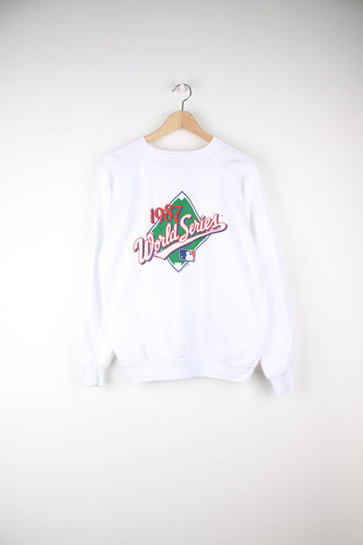 Vintage 1987 MLB World Series Sweatshirt in a white colourway, and has the logo and spell out printed across the front.