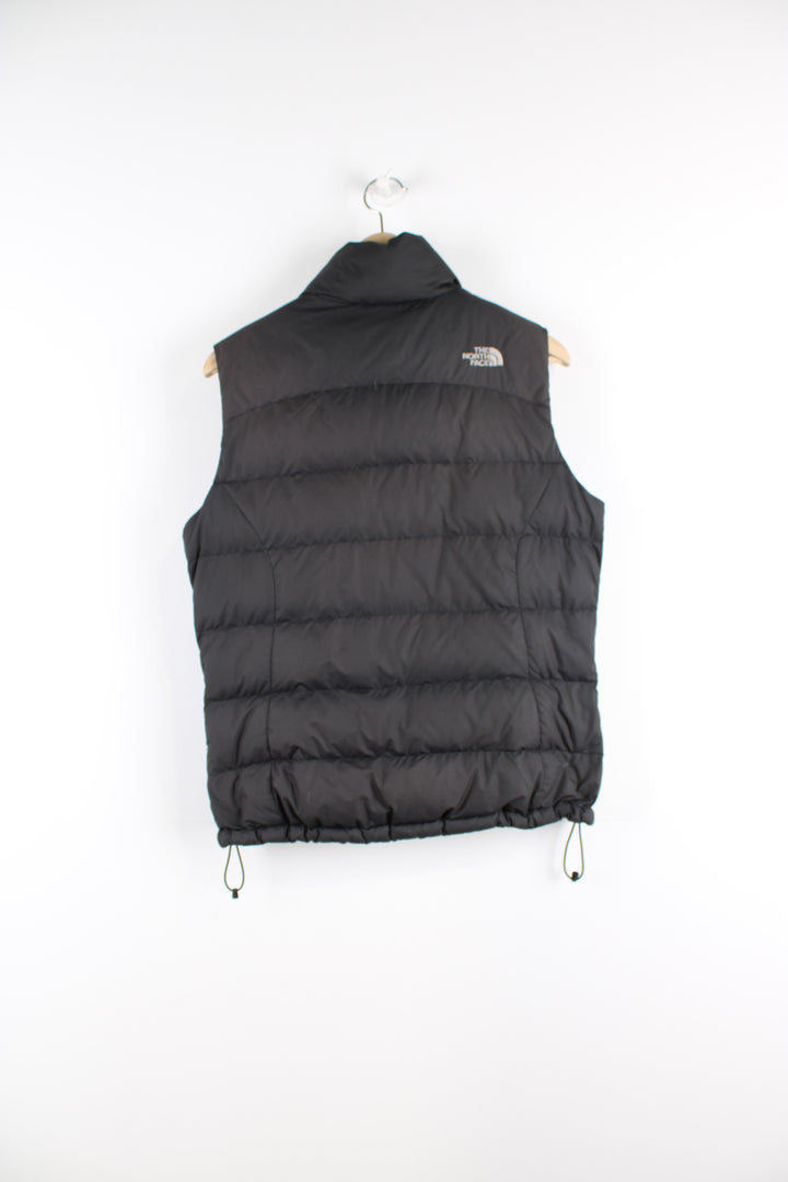 Women's The North Face 700 black puffer gilet with kangaroo pockets, draw string hem and embroidered logo on the front and back