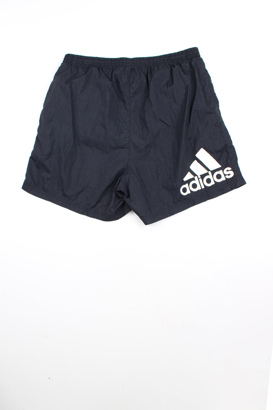 00's black Adidas sports shorts with elasticated waist and drawstring tie. Features white three stripe detail down the sides and has an embroidered logo on the front leg and printed logo on the back.