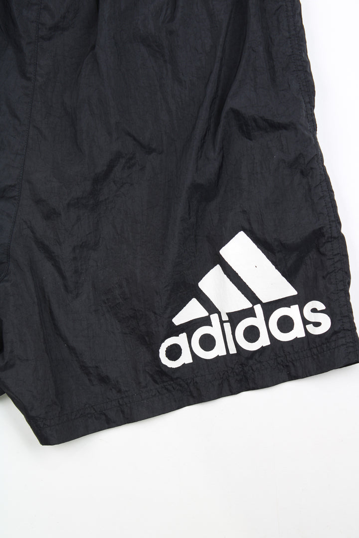 00's black Adidas sports shorts with elasticated waist and drawstring tie. Features white three stripe detail down the sides and has an embroidered logo on the front leg and printed logo on the back.