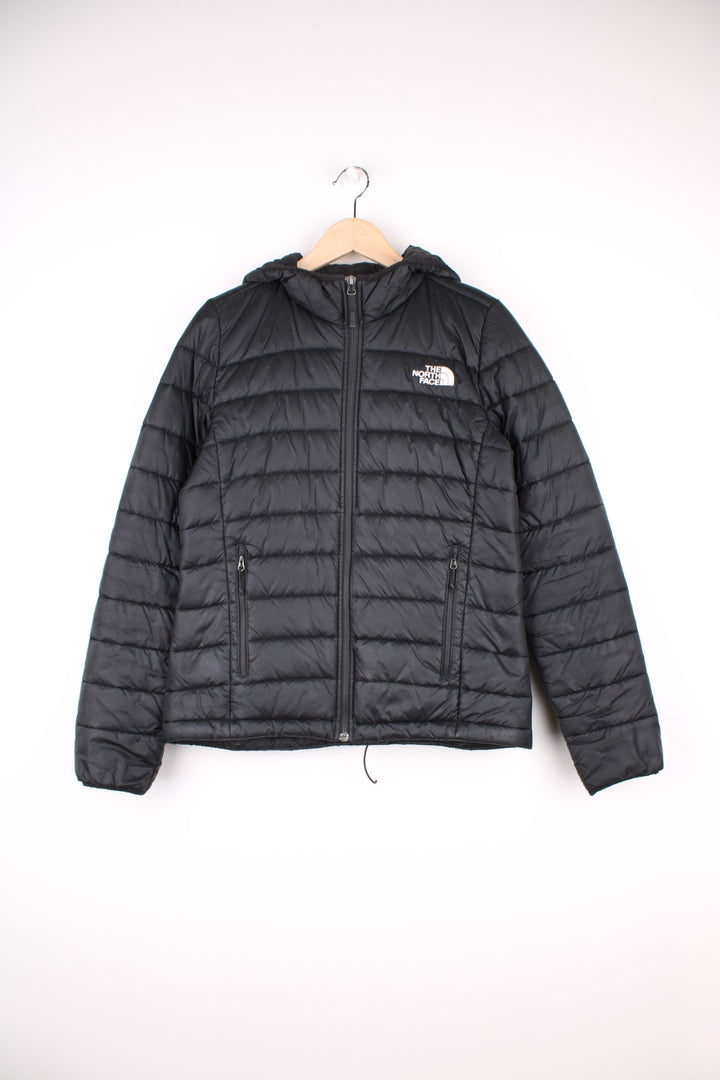 The North Face Puffer Jacket in a black colourway, zip up with side pockets, hooded, insulated, and has the logo embroidered on the front and back.