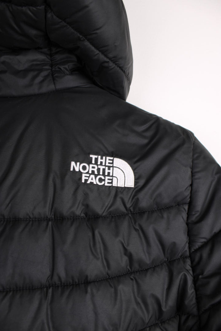 The North Face Puffer Jacket in a black colourway, zip up with side pockets, hooded, insulated, and has the logo embroidered on the front and back.