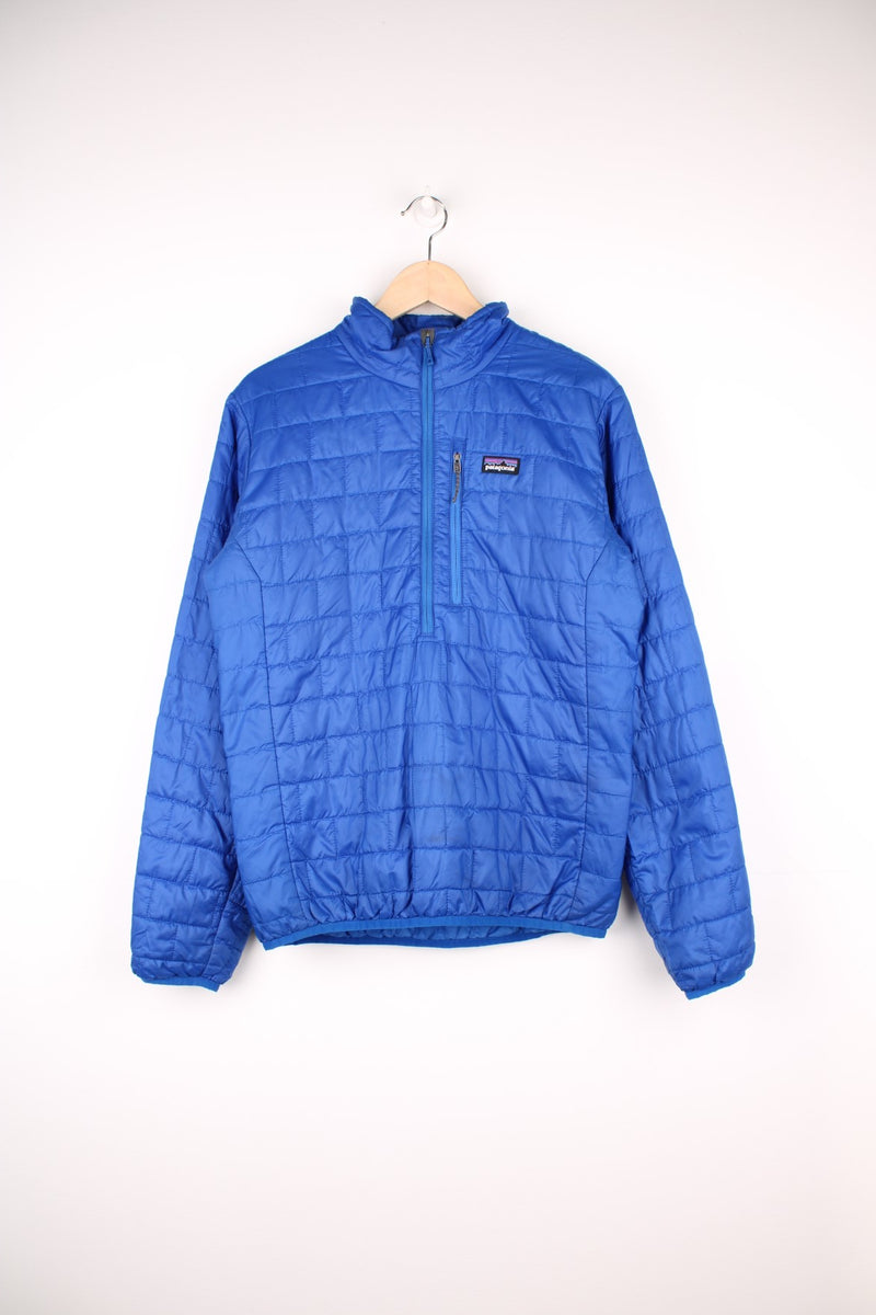 Patagonia Pullover Puffer Jacket in a blue colourway, half zip up with only one pocket on the chest, insulated, and has the logo embroidered on the front.