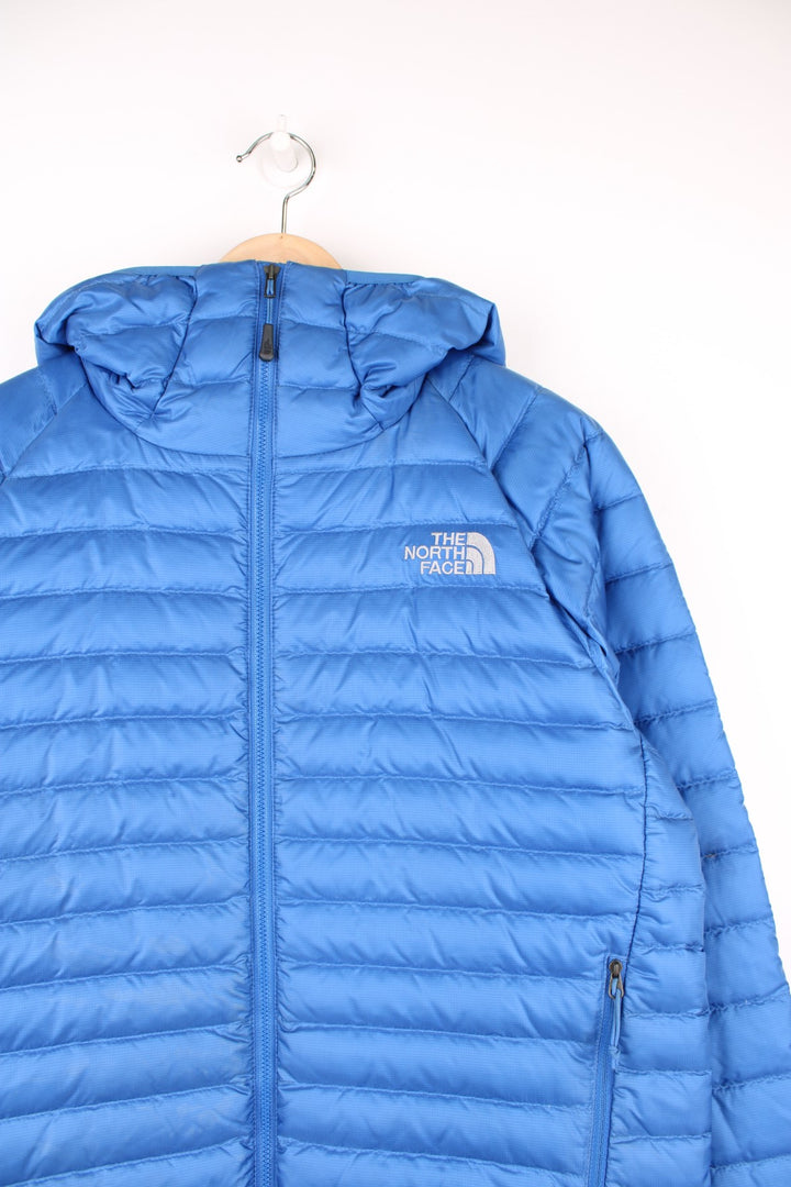 The North Face Puffer Jacket in a blue colourway, zip up with side pockets, hooded and has the logo embroidered on the front and back.