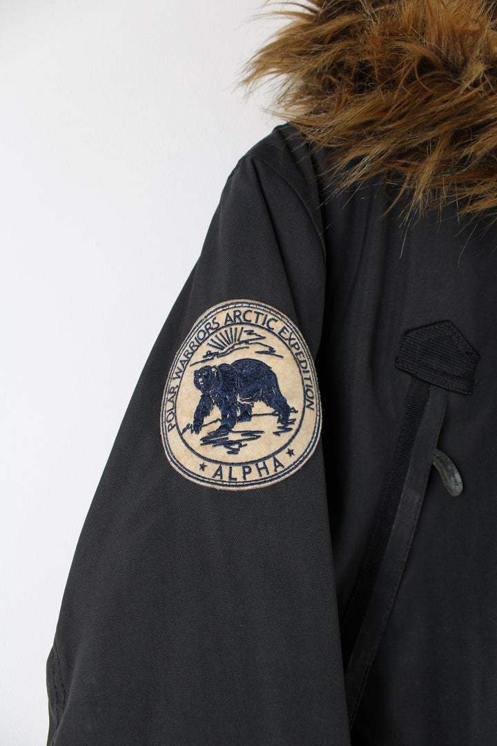 Vintage Alpha Industries hooded parka jacket in black, features multiple pockets, faux fur lined hood and embroidered patches on both arms.