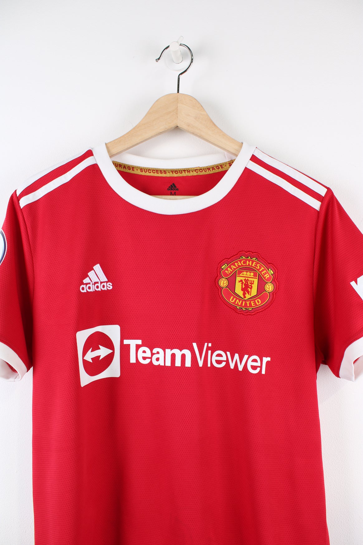 Manchester United 2021/22 home football shirt with Ronaldo number 7 on the back, has embroidered logos on the front and Premier League badge printed on the sleeve.