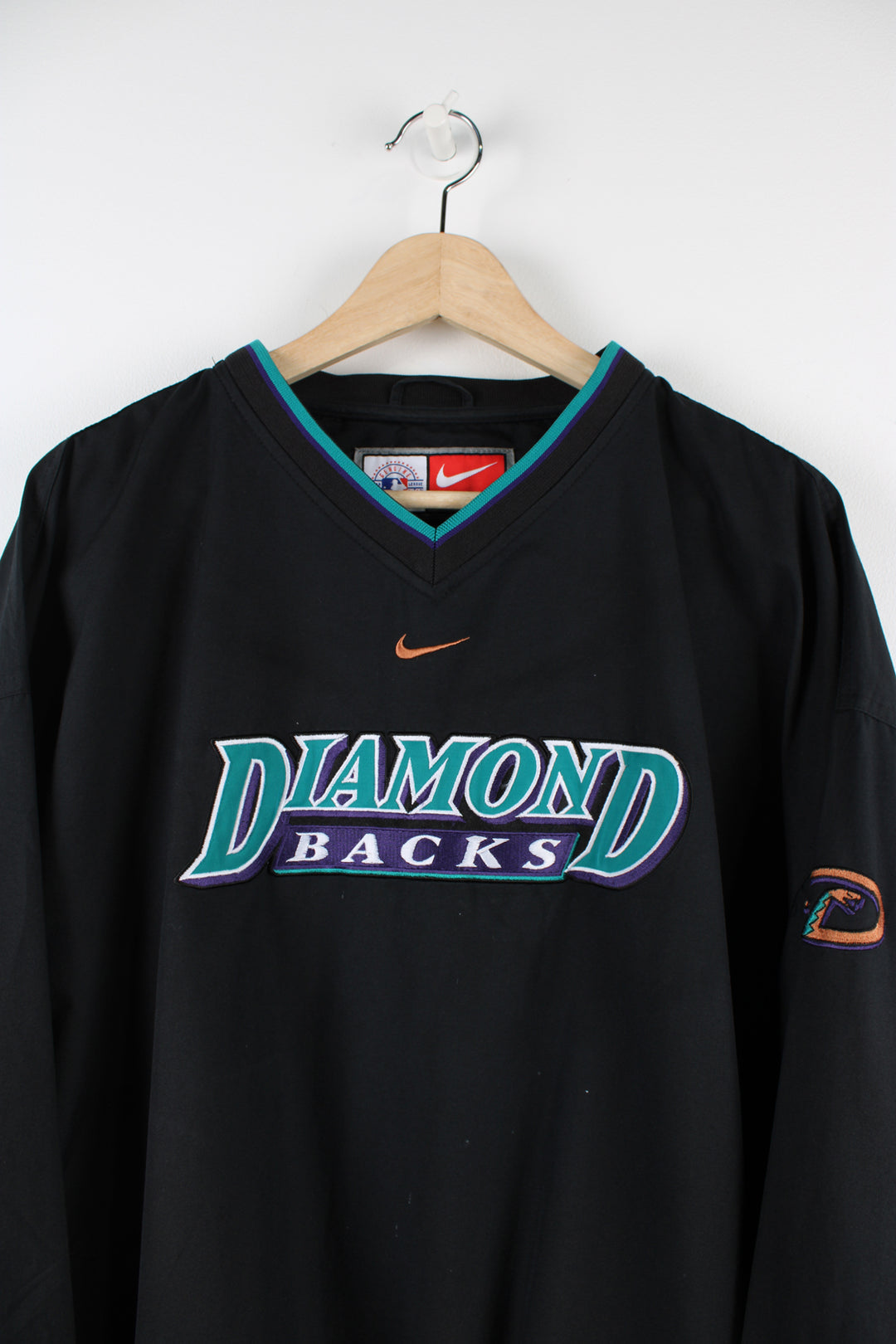 Vintage Nike Diamond Backs MLB training top in black, v neck with two side pockets, has centre swoosh and Diamond Backs spell-out on the front.