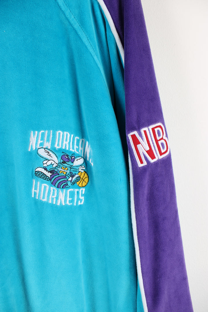 Vintage Charlotte Hornet NBA track jacket, blue, purple and white team colourway, zip up with side pockets, logo embroidered on the front and Hornets spell-out on the back.