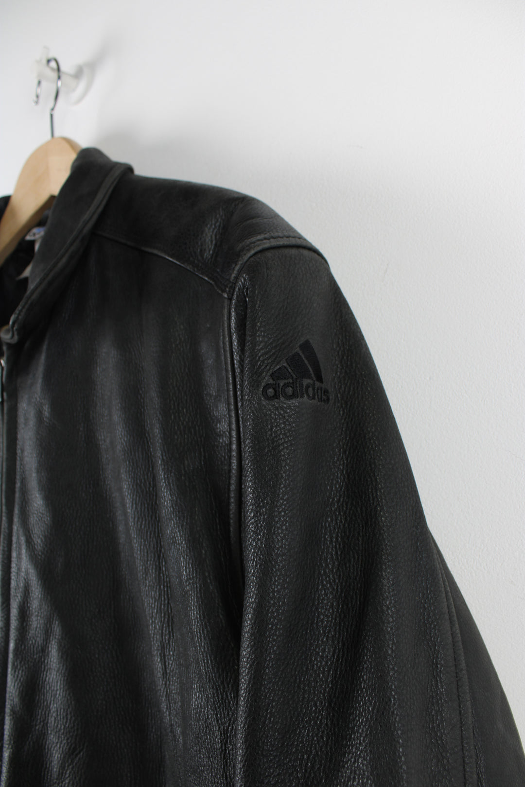 Vintage Adidas Boston Athletic Association leather jacket in black, zip up with two side pockets, has a quilted lining and embroidered logos on the sleeve and back of the jacket.