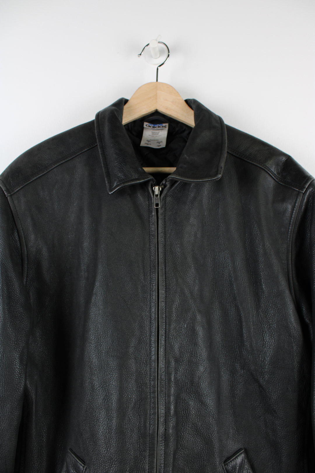 Vintage Adidas Boston Athletic Association leather jacket in black, zip up with two side pockets, has a quilted lining and embroidered logos on the sleeve and back of the jacket.