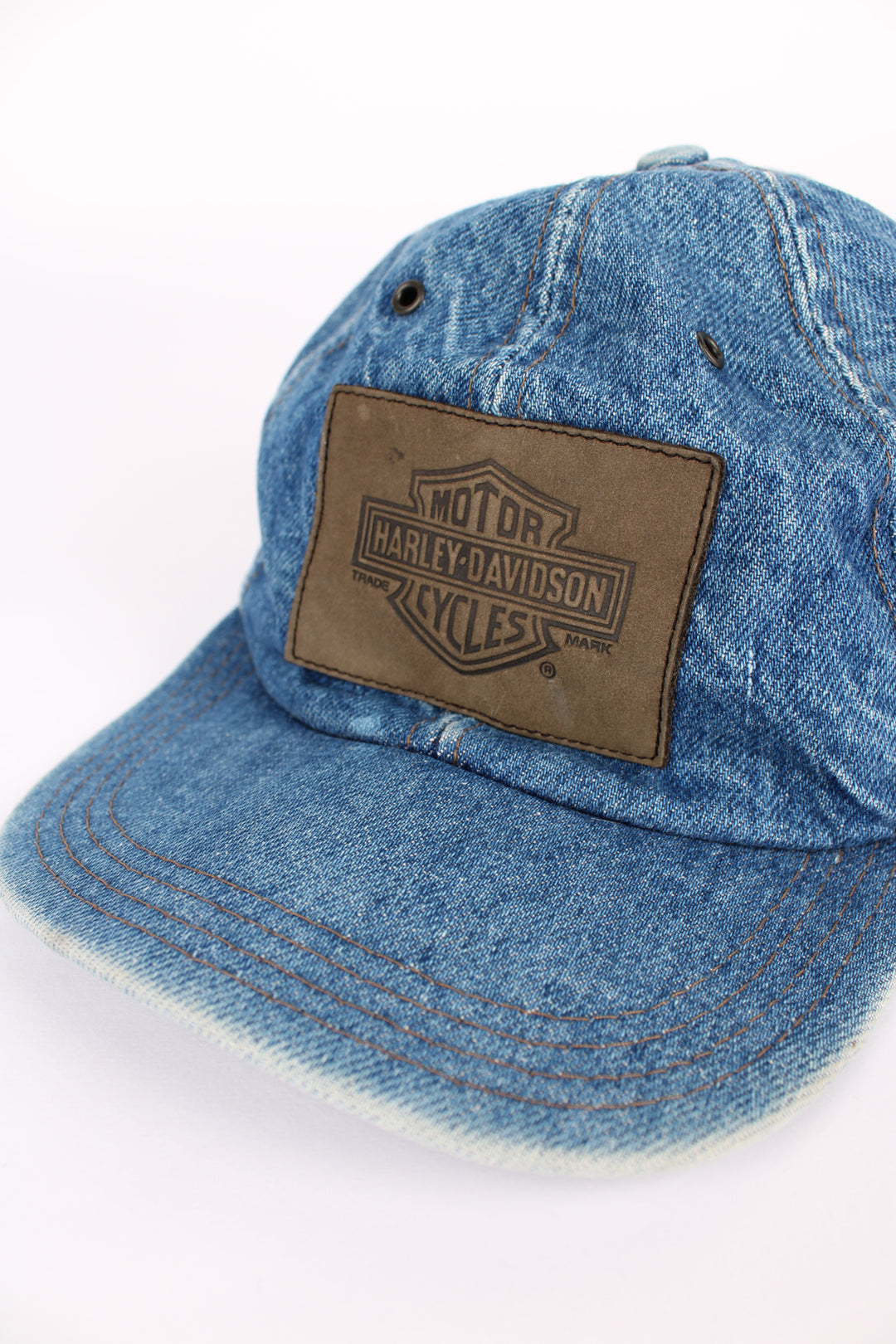 Vintage Harley Davidson denim blue cap, 100% cotton, made in USA, eyelet holes around the top, embroidered badge logo on the front and has an adjustable strap. 