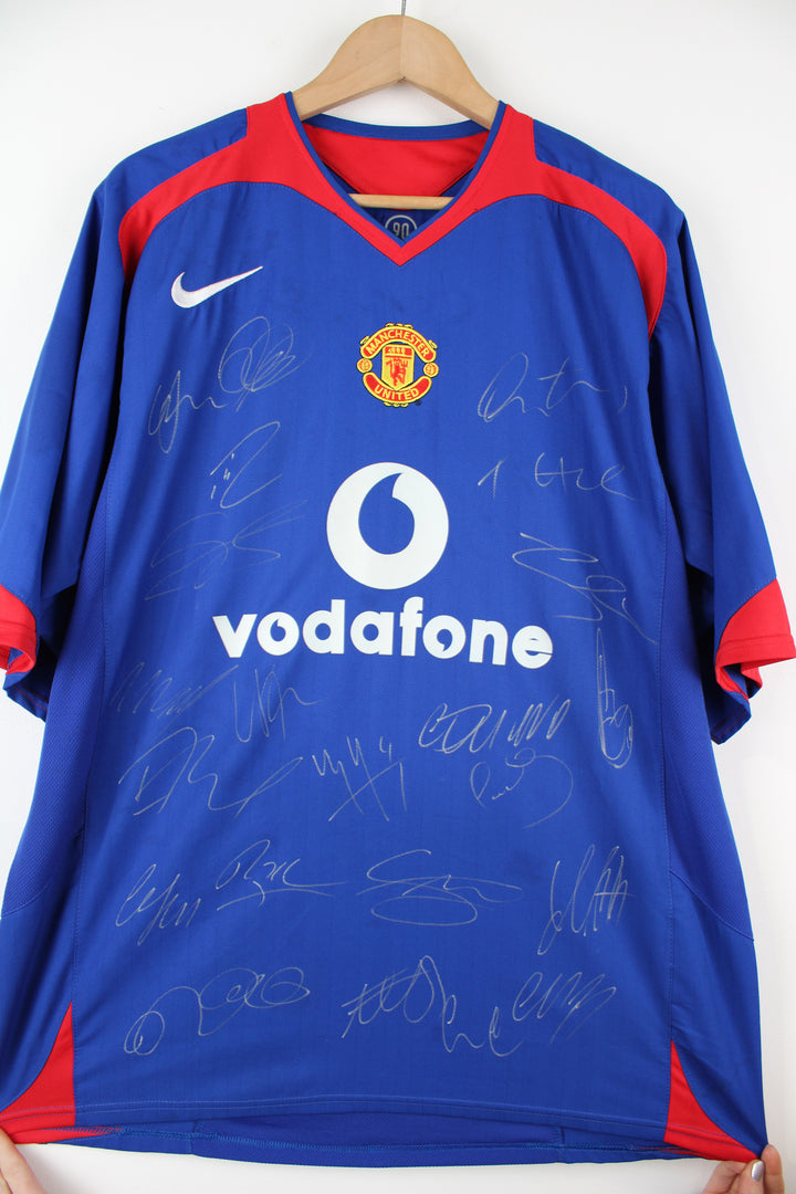 Manchester United 2005/06, Nike Football Kit in a blue, white and red colourway, signed by the players, V-neck and has logos printed on the front.