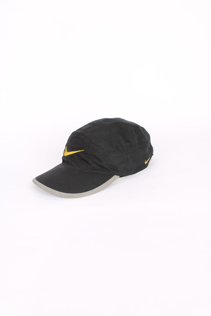 90's Nike cap in black, 100% polyester, adjustable strap, and yellow swoosh on the front.