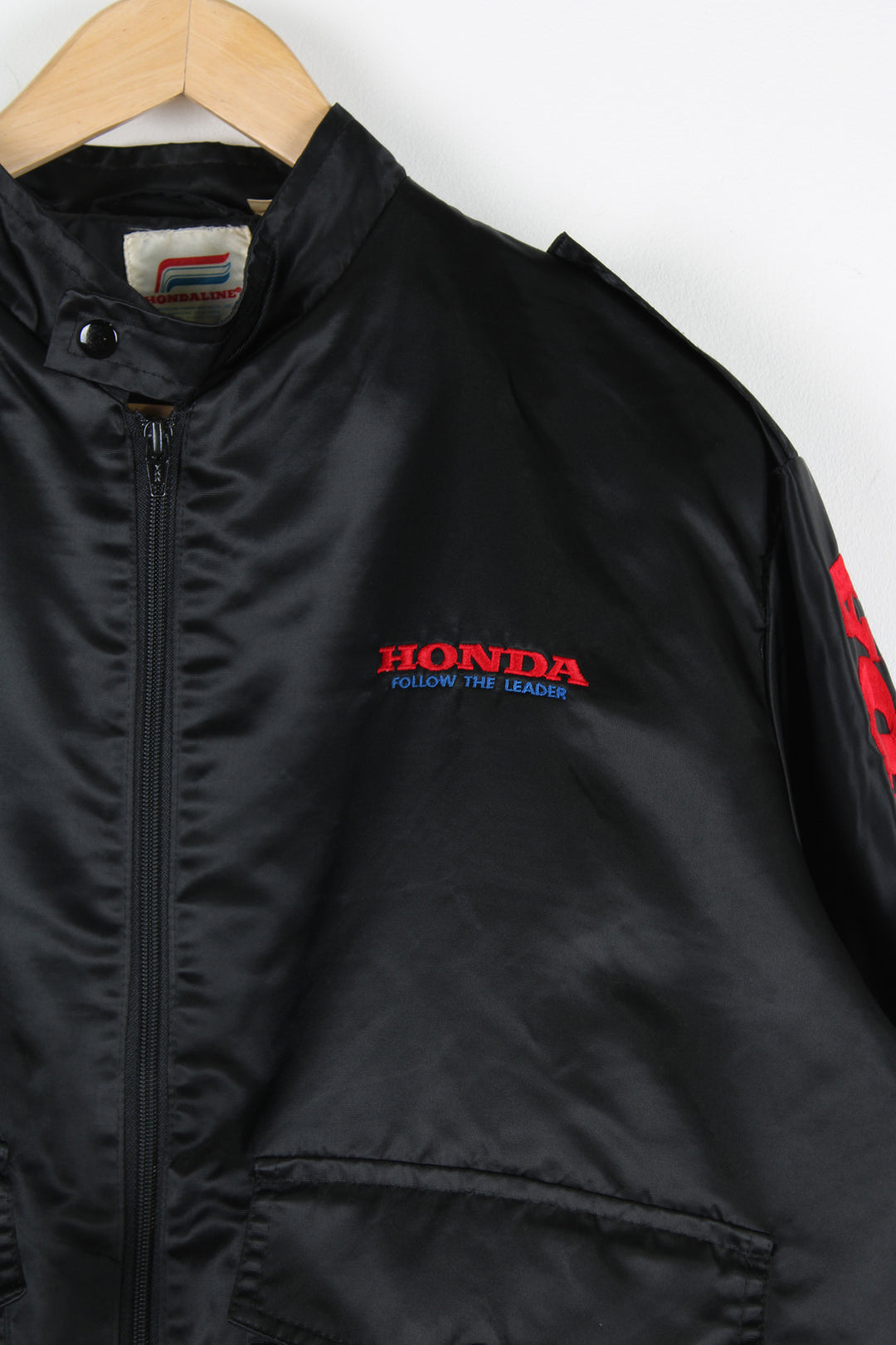 Vintage 1980's Honda black satin bomber jacket features embroidered spell-out details on the chest and down the sleeve 