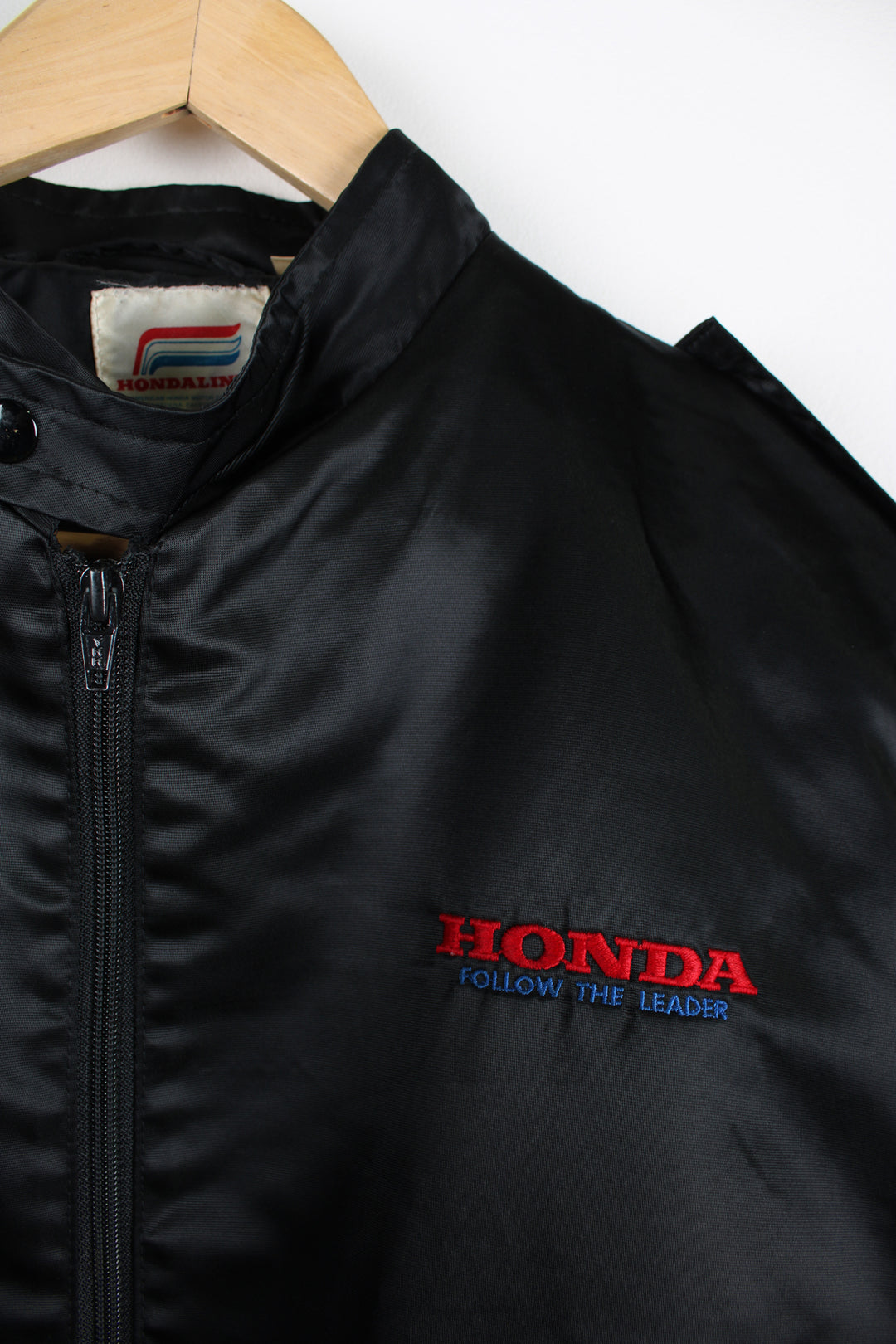 Vintage 1980's Honda black satin bomber jacket features embroidered spell-out details on the chest and down the sleeve 