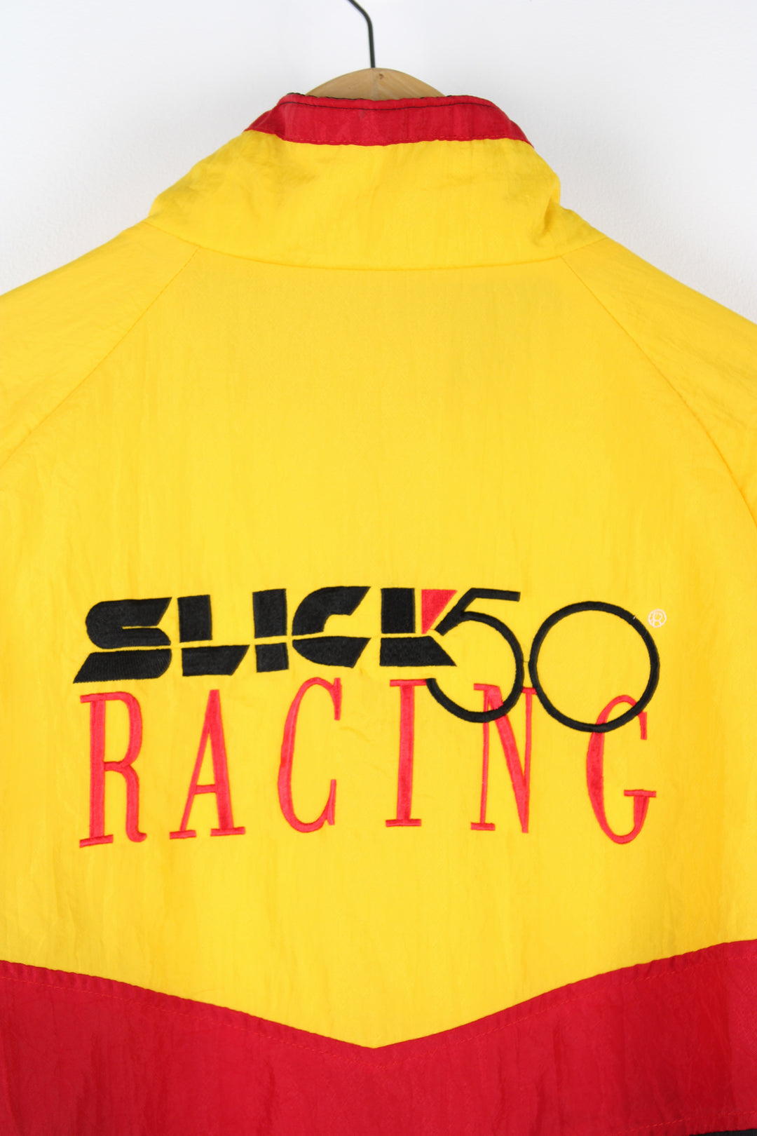 Slick Racing 50 red, yellow and black shell cropped racing jacket. Features embroidered spell-out details on the chest and across the back of the shoulders