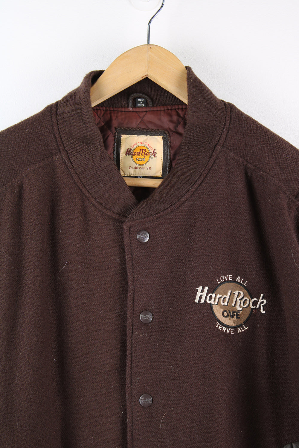 Vintage brown Hard Rock Hotel Paris varsity jacket with brown leather sleeves and embroidered badges on the front and back