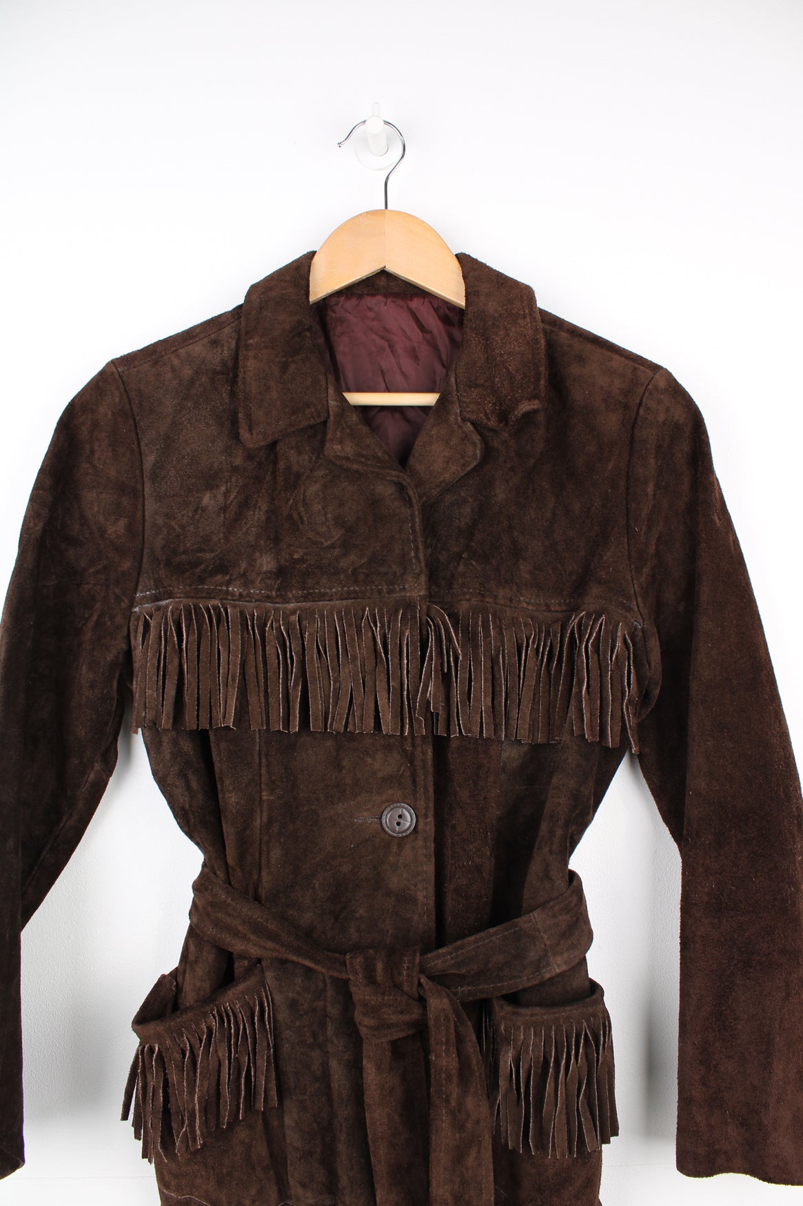 Vintage 1970s western style chocolate brown suede  jacket. Features belt, fringe detailing across the shoulders and down the sleeves and buttons for closure