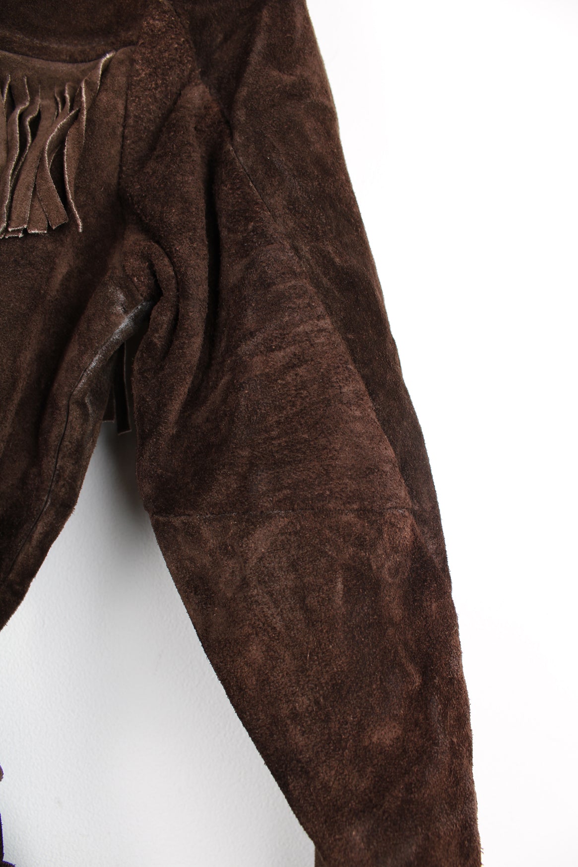 Vintage 1970s western style chocolate brown suede  jacket. Features belt, fringe detailing across the shoulders and down the sleeves and buttons for closure